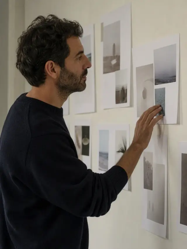 Un diseñador repasando pruebas impresas colgadas en la pared del estudio.